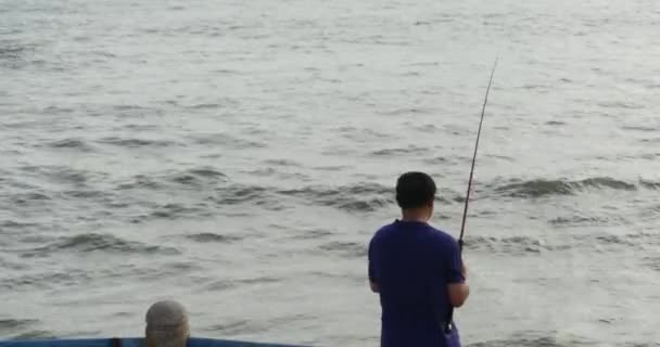 4k Hombre pescando en la costa . — Vídeo de stock