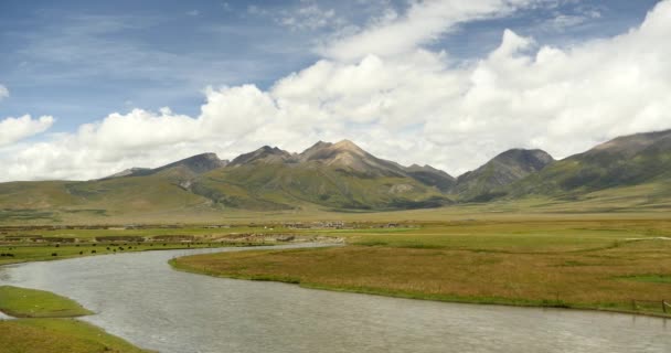 4k Wolkenmasse rollt über den Tibet-Berg, Fluss fließt durch die Prärie. — Stockvideo