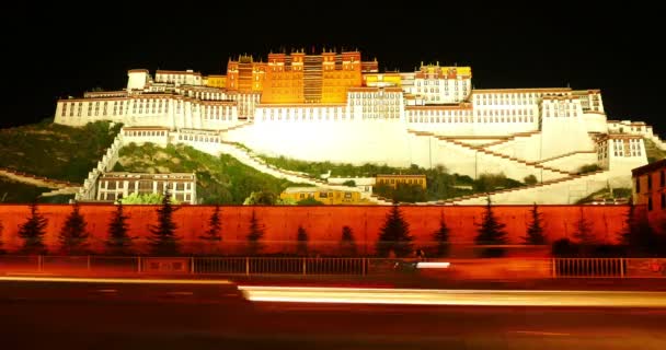 4k upptagen trafik i framsidan av Potala nattetid i Lhasa, Tibet. — Stockvideo