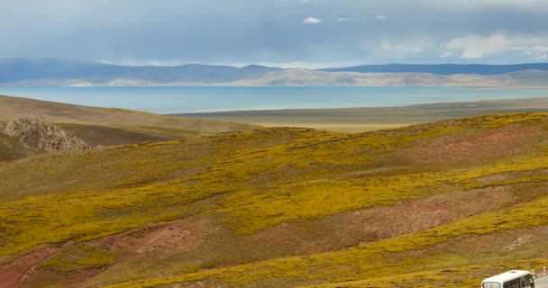 4 k bil körning på den slingrar sig vägen, avstånd sjön nomadiska & berg i tibet. — Stockvideo