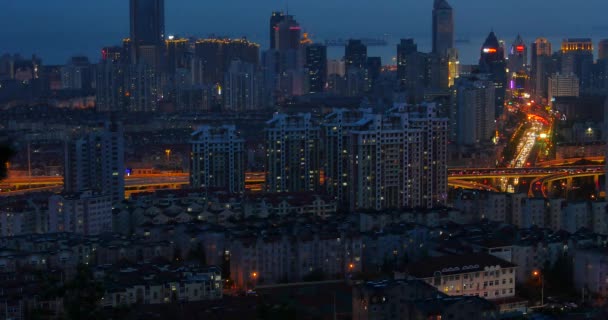 4k tráfico urbano ocupado en el paso elevado en la noche, edificio urbano morden, china de QingDao . — Vídeos de Stock