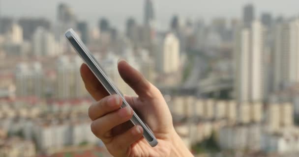 4k Mensch mit einem Smartphone aganist moderne städtische Gebäude Hintergrund. — Stockvideo