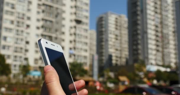 4k Una mujer usando un teléfono inteligente aganist negocio edificio fondo . — Vídeo de stock