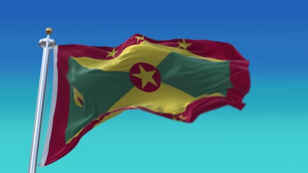 4k Grenada Ulusal bayrak kırışıklıkları mavi gökyüzü arka planında pürüzsüz rüzgar döngüsü. — Stok video