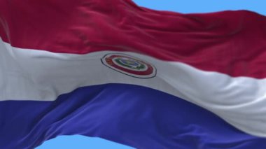 4k Paraguay Ulusal bayrak kırışıklıkları mavi gökyüzü arka planında pürüzsüz rüzgar döngüsü.