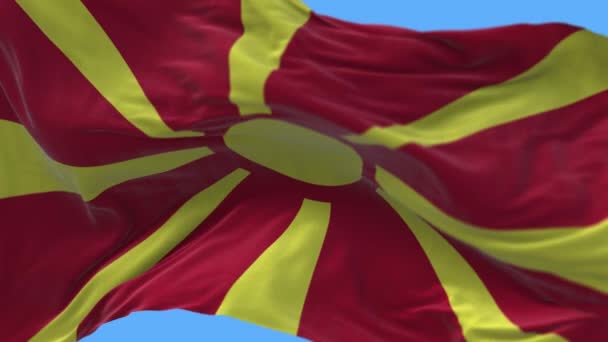 4k Macedonia del Norte Bandera Nacional arrugas sin costuras ondeando viento cielo fondo . — Vídeos de Stock