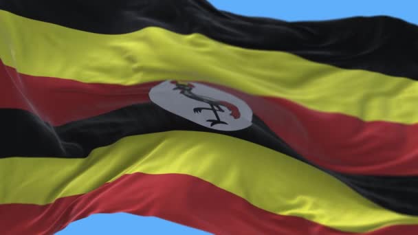 4k Uganda Narodowa flaga zmarszczki machanie wiatr niebo bezszwowe pętli tło. — Wideo stockowe