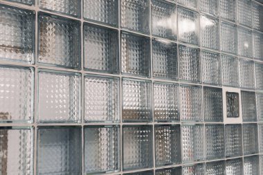 Yakından bakınca, çeşitli desenli desenlere sahip, doğal ışığın filtrelemesine izin veren, çağdaş estetik odaları geliştiren bir cam blok duvarı ortaya çıkıyor..