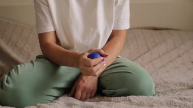 Sıcak bir yatak odasında, bir kadın el masajı teknikleri ve jimnastik egzersizleri yapar. Yakın plan görüntüsü, onun özgüvenine ve sağlığına odaklandığını vurguluyor..