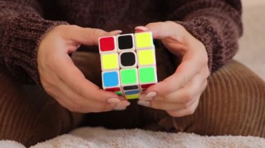 Chemnitz, Almanya - 06-09-2025: kadın Rubiks küpünü çözmeye odaklanıyor. Elleri küpü ustalıkla manipüle ediyor, problem çözme teknikleri ve stratejileri gösteriyor.