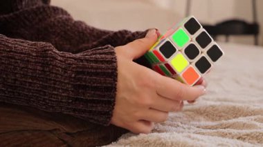 Chemnitz, Almanya - 06-09-2025: Bir kadın bir Rubiks küpünü çözmekle meşgul, yeteneklerini geliştirirken renk ve teknikleri yakından inceliyor.