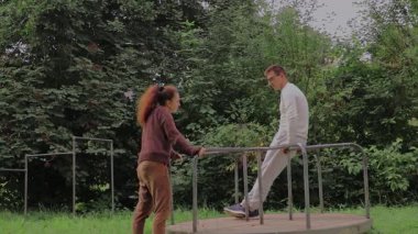 İki insan bir park atlıkarıncasında neşeli ruhlarını sergileyerek keyifli anları paylaşıyor. Bereketli yeşillik ve nazik atmosfer, açık havada kaliteli zaman geçirmeyi sevdikleri için bağlarını güçlendiriyor.