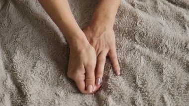 Genç bir kadın ellerindeki rahatsızlığı hisseder ve acıyı hafifletmek için kendine masaj ve nazik jimnastik yapar. El hareketliliğini ve rahatlığını geliştirmeye odaklanıyor..