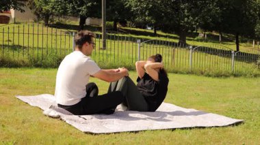 Bir çift arka bahçelerinde birlikte spor egzersizleri yapıyor, güzel havanın tadını çıkarırken güç ve esneklik gösteriyorlar. Birbirlerini motive ettiklerinde takım çalışmalarının bir göstergesi oluyor..