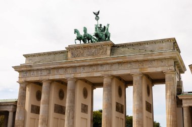 Berlin, Almanya - 1 Eylül 2025: Turistler Berlin 'deki Brandenburg Kapısı etrafında toplanarak güneşli havanın tadını çıkarıyorlar. Alman tarihini ve kültürünü temsil eden bu simge dimdik ayakta duruyor.