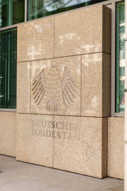 Berlin, Almanya - 1 Eylül 2025: Berlin 'de, Deutscher Bundestag binasında Alman kartal amblemi ile ayırt edici taş cephe bulunmaktadır. Bu tarihi yapı Alman siyasetinin merkezidir.