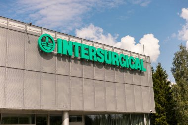 Visaginas, Litvanya - 22 Temmuz 2025: Modern bina Visaginas, Litvanya 'da parlak yeşil tabela sergiliyor. Yapı, açık mavi bir gökyüzü ve kabarık beyaz bulutların zeminine kurulmuştur.