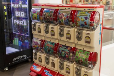 Visaginas, Litvanya - 22 Temmuz 2025: Alışveriş merkezinde çocukları ve aileleri çeken renkli oyuncak otomatları kurulmuştur. Çocuklar heyecanla en sevdiklerini seçiyorlar, ödüllerini keşfetmeye hevesliler..