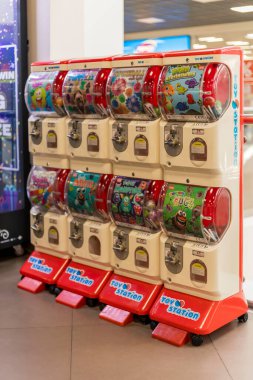 Visaginas, Litvanya - 22 Temmuz 2025: Litvanya 'nın Visaginas kentindeki bir alışveriş merkezinde renkli oyuncak otomatlar serisi bulunuyor. Aileler ve çocuklar oyuncak seçmek için toplanıyor..
