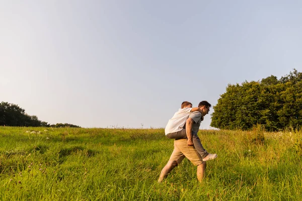 Bir baba, açık mavi gökyüzünün altındaki yemyeşil bir tarlayı keşfederken oğlunu sırtında taşır. Doğayla ve birbirleri ile bağ kurarak dışarıda iyi vakit geçirmeyi seviyorlar..