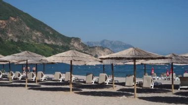 Budva, Karadağ, 27 Eylül 2018: Sandy Adriyatik sahil plaj şemsiyeleri ve plaj şezlong