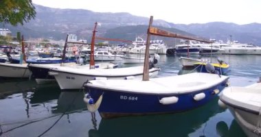 Budva, Karadağ 06 Ekim 2018: Adriyatik Denizi tabii. Balıkçı tekneleri Budva eski şehir yakınında sahildeki palamarla. Arka planda pitoresk dağlar görebilirsiniz