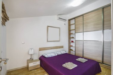 Windows bir Lüks villada bir modern yatak odası iç. Şık yatak odasında büyük rahat çift kişilik yatak