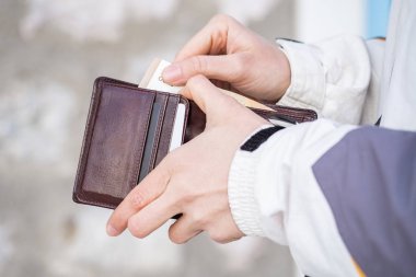 Kadın eli açık kahverengi deri cüzdan ve hafif bir arka plan bulanık gösteren euro para