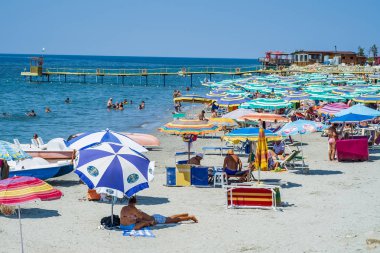Durres, Arnavutluk, 21 Ağustos 2018: Arnavut Durres yakın şehrin waterfront şehrin ana plaj. Biz sakin masmavi deniz, kumlu bir plaj, çok sayıda renkli şemsiye ve plaj şezlong, turistler ve yerliler, bir kalabalık görmek