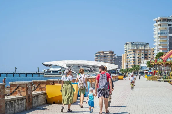 Durres, Arnavutluk, 21 Ağustos 2018: Arnavut şehir Durres çıkabilir. Vatandaşların ve turistlerin deniz kenarında yürüyüş. Ön planda bir çocukla turist bir grup var. Arka planda konut vardır
