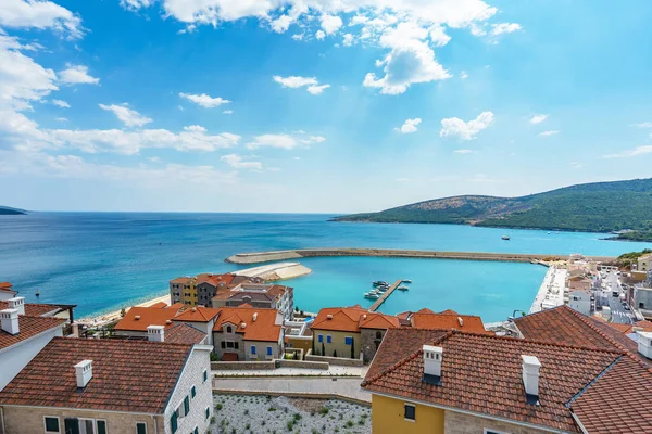 View from the private villa terrace of the roofs of the elite village houses and the marina with moored luxury yachts and boats