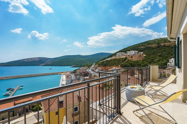 Spacious terrace in the villa with sea view. The terrace offers view on the roofs of the elite village houses and the marina with moored luxury yachts and boats