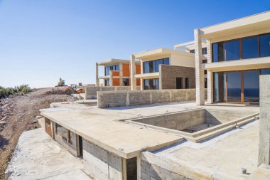 Bir güneşli bahar günü, Adriyatik kıyısındaki Villa Kompleksi İnşaatı şantiye. Bitmemiş bir binanın görünümü
