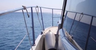 Lüks yat denize açılıyor, büyük köpüklü dalgalar yat omurgave yanlarından ayrılıyor. Dağlar tahtadan görülür