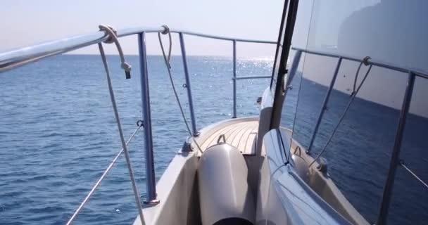 Yate de lujo está navegando en el mar, grandes olas espumosas divergen de la quilla y los lados del yate. Las montañas se ven desde el tablero — Vídeos de Stock