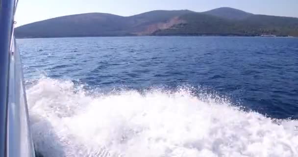 Yate de lujo está navegando en el mar, grandes olas espumosas divergen de la quilla y los lados del yate. Las montañas se ven desde el tablero — Vídeos de Stock