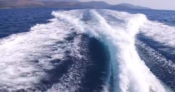Luxusjacht segelt im Meer, große schäumende Wellen weichen vom Kiel und den Seiten der Jacht ab. Berge sind von Bord aus zu sehen — Stockvideo