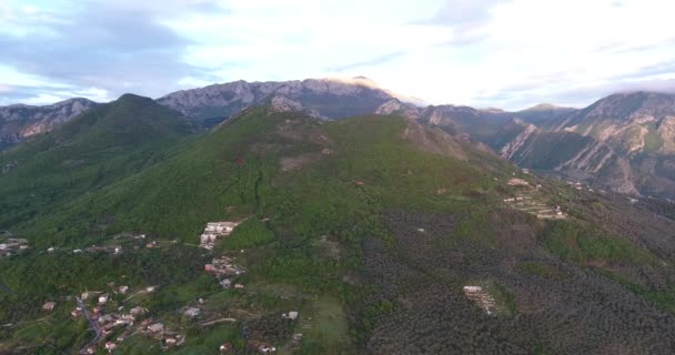 Letecká čtyřkopová střela z nedotčených lesů a silnic mezi nimi vysoko v horách v Jižní Černé hoře. Slunce osvětluje vrchol hory — Stock video