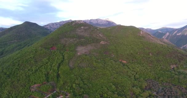 Aerial quadcopter laukaus koskematon metsät ja tiet niiden välillä korkealla vuoristossa Etelä-Montenegrossa. Aurinko valaisee vuoren huipun. — kuvapankkivideo