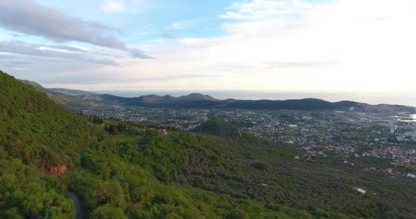 Légi quadcopter lövés a zöld montenegrói városi bár, fekszik az Adriai-tenger partján, a naplemente a tavasszal. Hegyet a háttérben — Stock videók