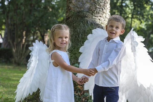 Barn klädda som änglar går i parken — Stockfoto