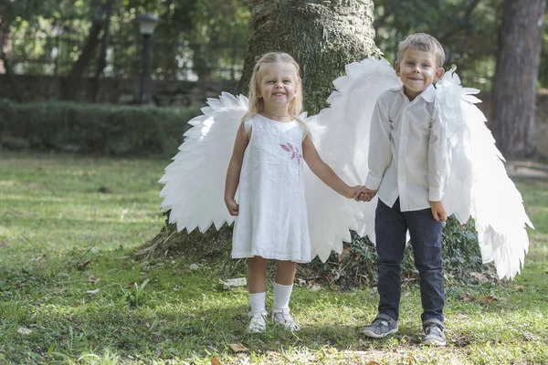 Anak-anak berpakaian seperti malaikat berjalan di taman Stok Lukisan  