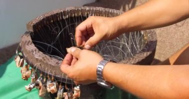 Denizde balık tutmak. Teknedeki balıkçılar oltaya yem takıyor. Pangan ve oltaya yem takılmış oltaya yakın çekim