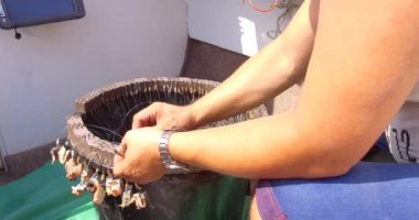 Denizde balık tutmak. Teknedeki balıkçılar oltaya yem takıyor. Pangan ve oltaya yem takılmış oltaya yakın çekim