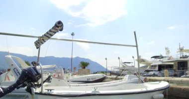 Budva, Karadağ, 25 Ağustos 2020: Adriyatik kıyısındaki küçük bir kasabanın Marina manzarası. Beyaz yatlar ve motorlu tekneler dalgalar üzerinde sallanıyor. Kapalı beyaz sürat teknesi