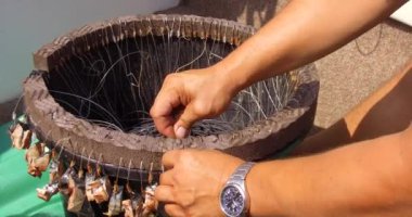 Denizde balık tutmak. Teknedeki balıkçılar oltaya yem takıyor. Pangan ve oltaya yem takılmış oltaya yakın çekim