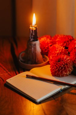 Mum, açık defter, kalem ve ahşap masada kasımpatı ile rahat bir hayat. Ilık sonbahar havası, günlük tutmak, çalışmak ya da yaratıcı ilham için mükemmel..