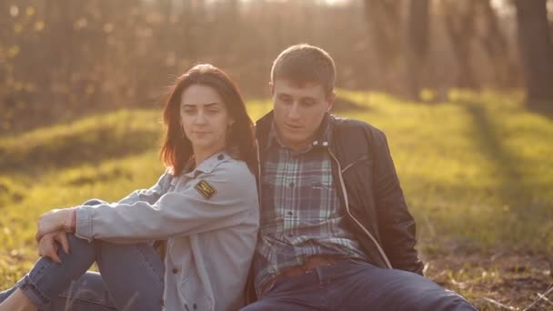 A couple in love is sitting on a green meadow in early spring — Stock Video