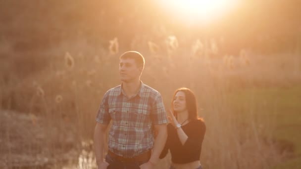 The girl approaches her boyfriend and gently hugs. A loving couple meets together the sunset in a romantic setting — Stock Video