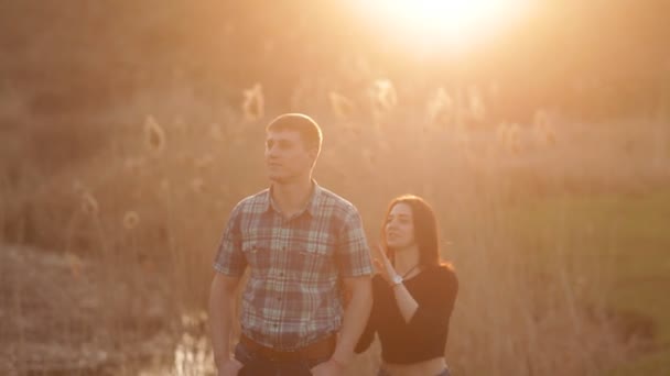 Kız erkek arkadaşı yaklaşımlar ve yavaşça sarılarak. Sevgi dolu bir çift birlikte günbatımı romantik bir ortamda karşılamaktadır — Stok video